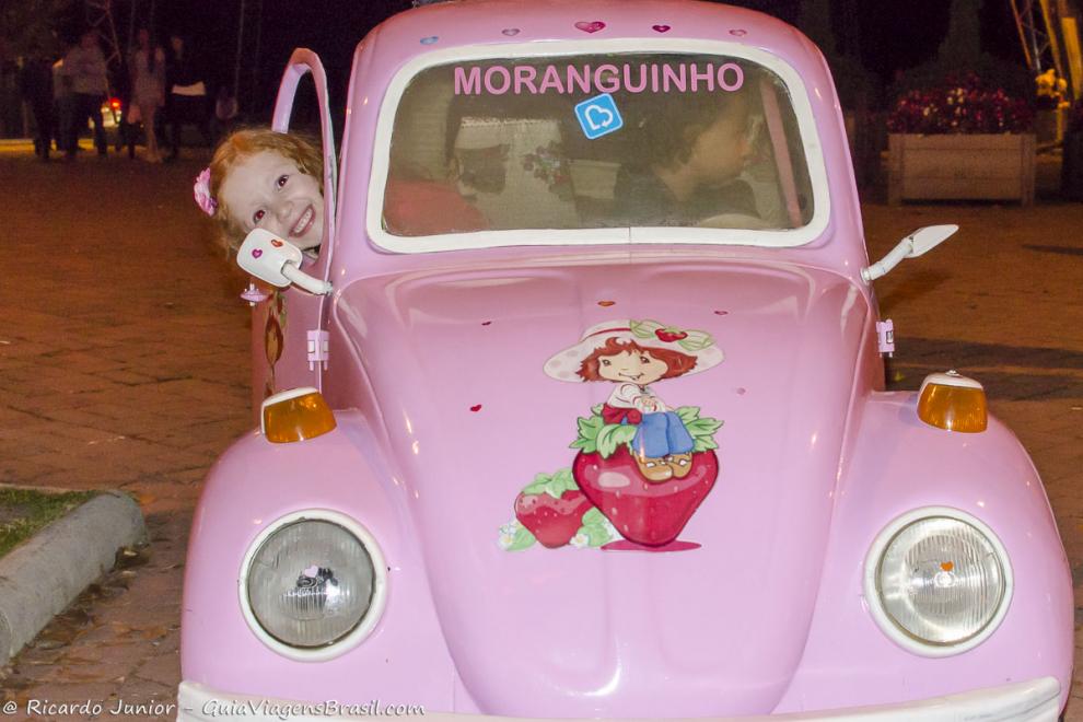 Imagem de duas crianças em um mini carro rosa em Campos do Jordão.